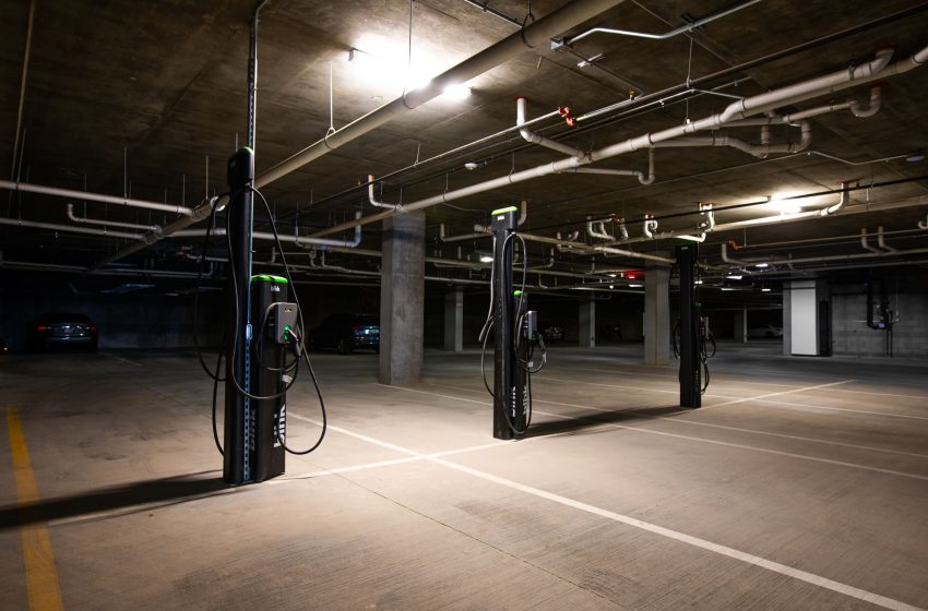 Electric vehicle charging stations in a dimly lit underground parking garage.